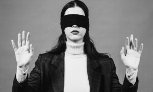Woman wearing a blindfold, representing missed internal communications