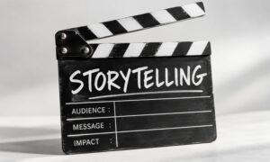 Black-and-white film clapperboard featuring the word ‘Storytelling’ and the labels ‘Audience’, ‘Message’ and ‘Impact’.